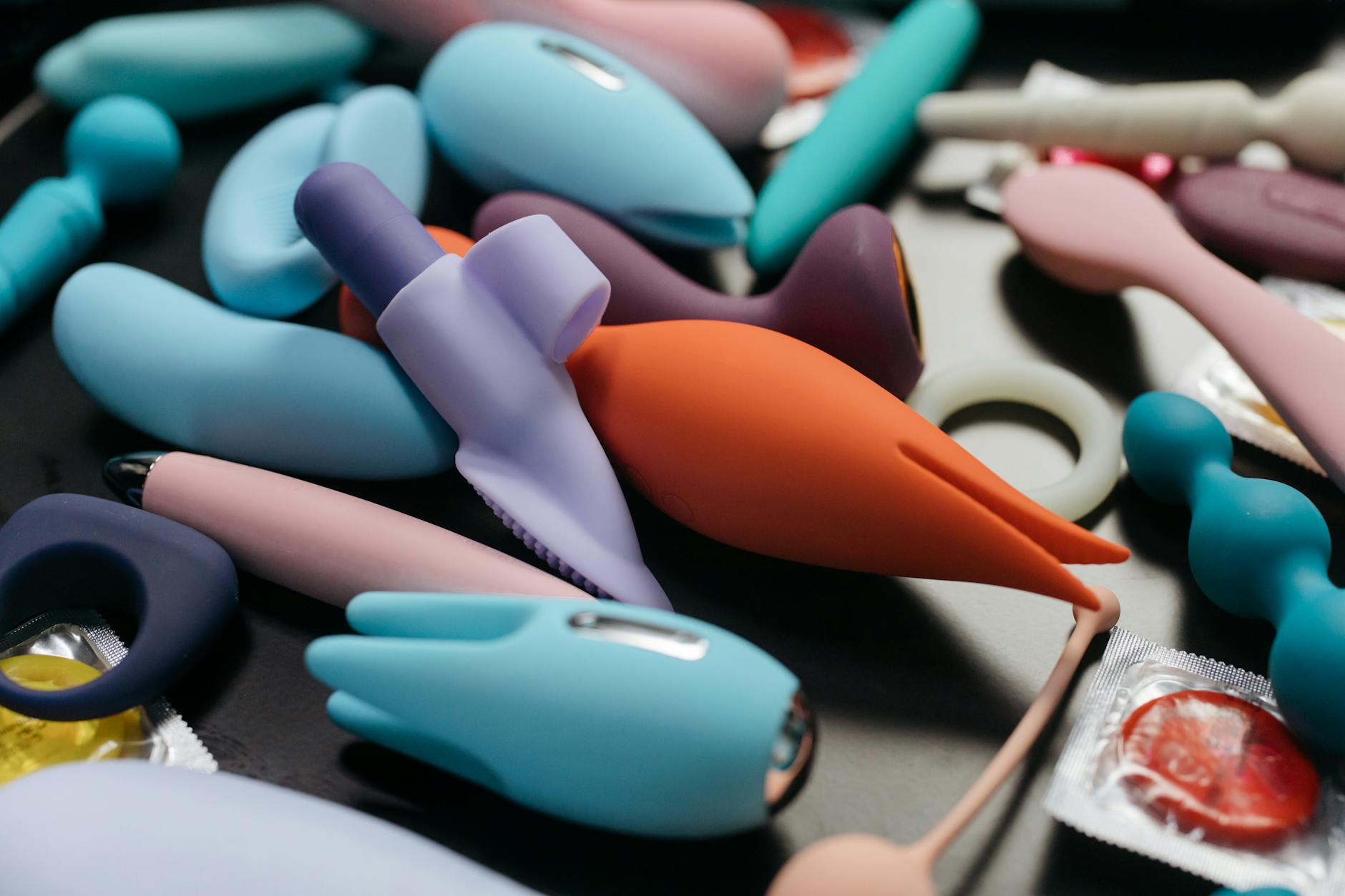 A hand holding a vibrator against a minimalistic purple backdrop, showcasing modern sensuality and control