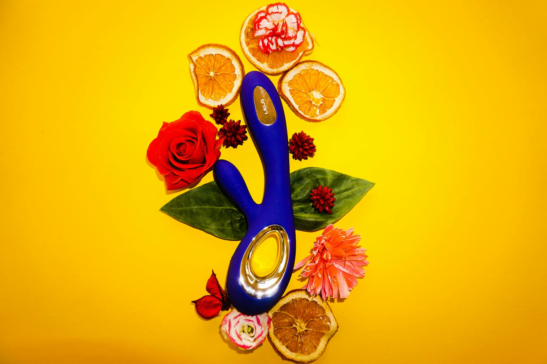 A vibrant lemon-colored vibrator surrounded by fresh citrus fruit and flowers on a bright yellow background, symbolizing refreshment and renewal.
