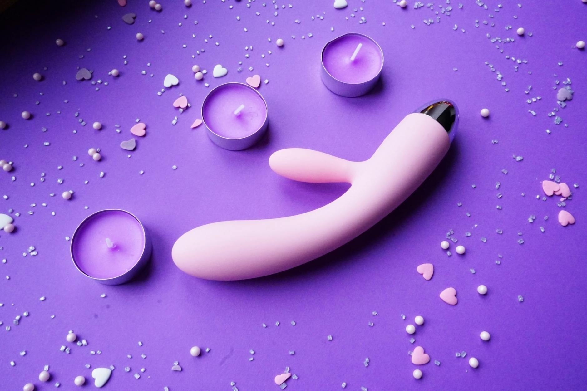 Vibrator nestled among candles and rose petals, symbolizing intimacy and shared pleasure.